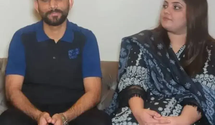 A heartfelt moment showing a Pakistani man holding hands with his recovering wife in a hospital room after donating 60% of his liver, symbolizing love, sacrifice, and hope.