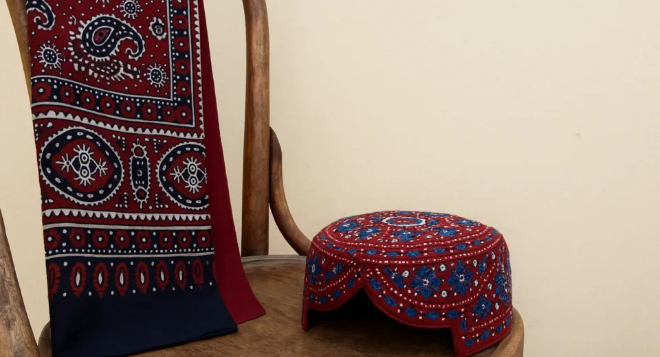 Ajrak shawl and Sindhi topi placed on a wooden chair, symbolizing Sindh’s cultural identity amid recent 2025 government restrictions at public events