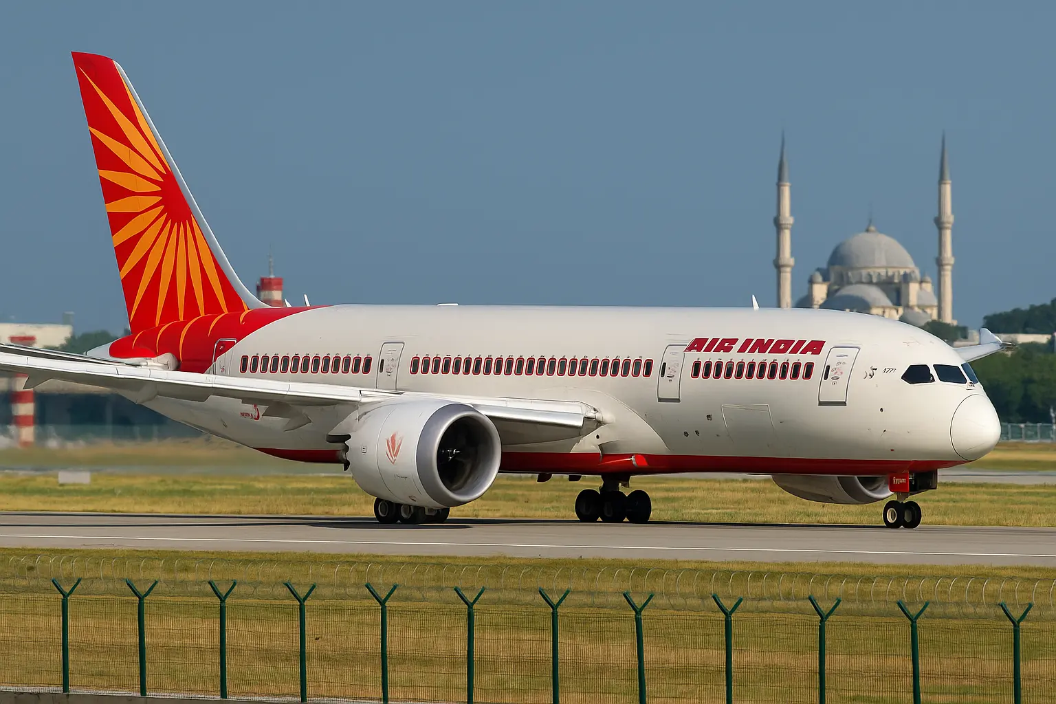A high-resolution digital photograph captures an Air India Boeing 787-8 Dreamliner taxiing on the runway under a clear blue sky. The aircraft features its signature red and orange livery, with a mosque featuring domes and twin minarets visible in the background, symbolizing the geopolitical context of restricted airspace between India and Pakistan.
