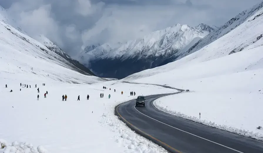 Snow-covered landscape at Babusar Top in May 2025, with misty mountains and tourists enjoying unexpected spring snowfall in Kaghan Valley, Pakistan.
